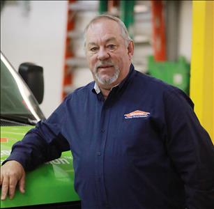 A man standing in front of a green SERVPRO van