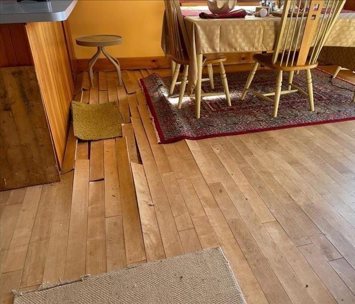 Wood floor showing cupping from prolonged water damage.